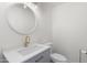 Cozy half-bath features modern fixtures, vanity, and round mirror at 2614 E Mountain View Rd, Phoenix, AZ 85028