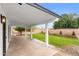 Covered patio overlooks a large backyard with mature trees, ideal for outdoor dining and relaxation at 2614 E Mountain View Rd, Phoenix, AZ 85028