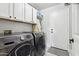 Modern laundry room with front loading washer and dryer and ample cabinet storage space at 26271 N 46Th St, Phoenix, AZ 85050