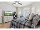 Comfortable main bedroom features a ceiling fan, a tv, and an arched window with wooden shutters at 26271 N 46Th St, Phoenix, AZ 85050