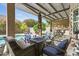 Cozy covered patio with a fire pit, comfortable seating, and a view of the pool and landscaped backyard at 26271 N 46Th St, Phoenix, AZ 85050