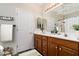 Well-lit bathroom featuring a double vanity with wood cabinets, decorative mirrors, and a neutral color scheme at 2641 E Brooks St, Gilbert, AZ 85296