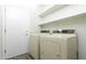 Laundry room with white washer and dryer units, shelving, and a door to the exterior at 2641 E Brooks St, Gilbert, AZ 85296