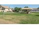 Outdoor recreational area with a volleyball court next to a neighborhood covered playground on the green grass at 2641 E Brooks St, Gilbert, AZ 85296