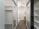 A walk-in closet with mirrored sliding doors, wood plank floors, and white painted walls at 2641 E Brooks St, Gilbert, AZ 85296