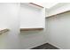 Empty walk-in closet featuring wood rods, white shelving, and wood plank floors at 2641 E Brooks St, Gilbert, AZ 85296