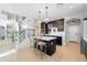 Open kitchen with island seating, dark wood cabinets, and adjacent staircase with decorative wall art at 28408 N 52Nd Way, Cave Creek, AZ 85331