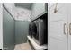 Convenient laundry room with modern washer and dryer, custom cabinetry, and stylish wallpaper accent at 28408 N 52Nd Way, Cave Creek, AZ 85331