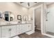 This bathroom features a double sink vanity, white cabinets and tile, and a glass shower at 3105 E Amber Ridge Way, Phoenix, AZ 85048