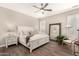 Bright main bedroom features a white bed frame, modern ceiling fan, and wood-look flooring at 3105 E Amber Ridge Way, Phoenix, AZ 85048