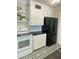 Modern kitchen with black refrigerator, white cabinets, and black and white patterned floor at 3202 N 21St St, Phoenix, AZ 85016