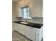 Bright kitchen featuring white cabinets, elegant black countertops, and modern appliances at 3202 N 21St St, Phoenix, AZ 85016