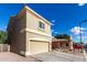 A side view of a two-story tan stucco home with a two car garage at 337 N 103Rd Pl, Apache Junction, AZ 85120