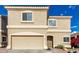 Close-up of a two-story tan stucco home with a two car garage at 337 N 103Rd Pl, Apache Junction, AZ 85120