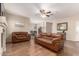 Inviting living room featuring wood floors, a ceiling fan, and comfortable leather sofas at 337 N 103Rd Pl, Apache Junction, AZ 85120