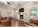 A cozy living room with a fireplace and ceiling fan is ready to entertain at 337 N 103Rd Pl, Apache Junction, AZ 85120