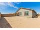 View of the back of the house with a large dirt backyard with potential for landscaping at 343 S 202Nd Dr, Buckeye, AZ 85326
