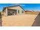 View of the back of the house with a large dirt backyard enclosed by a tall brick wall at 343 S 202Nd Dr, Buckeye, AZ 85326