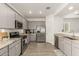 Well-lit kitchen features stainless appliances, granite countertops, gray cabinets and wood tile flooring at 343 S 202Nd Dr, Buckeye, AZ 85326
