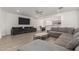 Open concept living area features a gray sectional, tile floors, neutral paint and easy access to the kitchen at 343 S 202Nd Dr, Buckeye, AZ 85326