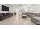 Open concept living area features a gray sectional, tile floors, neutral paint and easy access to the kitchen at 343 S 202Nd Dr, Buckeye, AZ 85326