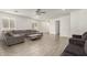 Spacious living room with neutral walls, gray sofas, tile flooring, ceiling fan, and plenty of natural light at 343 S 202Nd Dr, Buckeye, AZ 85326