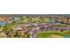 An aerial view displays an elegant clubhouse surrounded by palm trees, a golf course, and manicured landscapes at 3800 S Cantabria Cir # 1077, Chandler, AZ 85248
