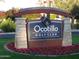 Elegant stone community sign with vibrant floral accents, set against a backdrop of lush greenery and blue skies at 3800 S Cantabria Cir # 1077, Chandler, AZ 85248
