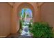 Inviting arched entryway framing a view of a well-manicured front yard and beautiful home beyond at 3800 S Cantabria Cir # 1077, Chandler, AZ 85248
