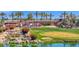 Scenic golf course view featuring a serene pond, a waterfall, lush greenery, and colorful floral accents at 3800 S Cantabria Cir # 1077, Chandler, AZ 85248