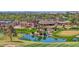 Picturesque view of a golf course with a clubhouse, water features, manicured landscaping, and mature trees at 3800 S Cantabria Cir # 1077, Chandler, AZ 85248