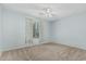 Bedroom with neutral carpet, ceiling fan, and a sunny window with patterned curtains at 408 N Falcon Ct, Gilbert, AZ 85234