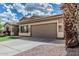 This home features a two-car garage with a large driveway and desert landscaping at 408 N Falcon Ct, Gilbert, AZ 85234