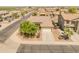 Elevated view of a single-story home featuring a two-car garage, desert landscaping, and neighborhood surroundings at 44574 W High Desert Trl, Maricopa, AZ 85139