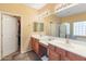 Well-lit bathroom with dual sinks, a large mirror, and a separate room for the shower and tub at 44574 W High Desert Trl, Maricopa, AZ 85139