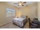 Welcoming bedroom with ceiling fan, plush carpet and large window filling the space with light at 44574 W High Desert Trl, Maricopa, AZ 85139