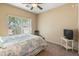 Bright bedroom with large window, neutral tones, and ceiling fan creating a relaxing atmosphere at 44574 W High Desert Trl, Maricopa, AZ 85139