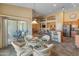 Bright dining area with a glass table, wicker chairs, and seamless access to the outdoor patio at 44574 W High Desert Trl, Maricopa, AZ 85139