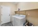 Clean laundry room features a modern washer and dryer and ample storage space at 44574 W High Desert Trl, Maricopa, AZ 85139