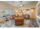 Bright living room features large windows, comfortable seating, and a view of the pool at 44574 W High Desert Trl, Maricopa, AZ 85139