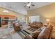 Open floorplan features comfortable seating, a ceiling fan, and seamless flow to the kitchen at 44574 W High Desert Trl, Maricopa, AZ 85139