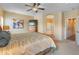 Spacious bedroom with neutral tones, plush carpeting, and an arched doorway to the en-suite bathroom at 44574 W High Desert Trl, Maricopa, AZ 85139