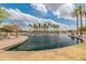 Community pond with palm trees, walking paths, and benches at 44574 W High Desert Trl, Maricopa, AZ 85139