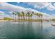 Scenic view of community pond with palm trees and fountains at 44574 W High Desert Trl, Maricopa, AZ 85139