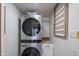 Efficient laundry room showcasing a stacked washer and dryer, and a convenient countertop with storage space at 4502 N 17Th Ave, Phoenix, AZ 85015