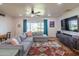 Cozy living room featuring a plush sectional sofa, floor lamp, and large window with view of the front yard at 4502 N 17Th Ave, Phoenix, AZ 85015