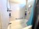 Clean bathroom featuring a shower-tub combination with a white tile surround and built-in shelving at 4601 W Fortune Dr, Anthem, AZ 85086