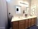 Double sink bathroom with a wooden vanity, neutral walls, framed mirrors and ample counter space at 4601 W Fortune Dr, Anthem, AZ 85086