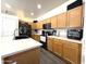 Well-lit kitchen with wood cabinets, stainless steel appliances and an island sink at 4601 W Fortune Dr, Anthem, AZ 85086