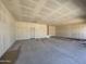 Spacious three-car garage with concrete floor, drywall, and door to home's interior at 46887 W Old Timer Rd, Maricopa, AZ 85139